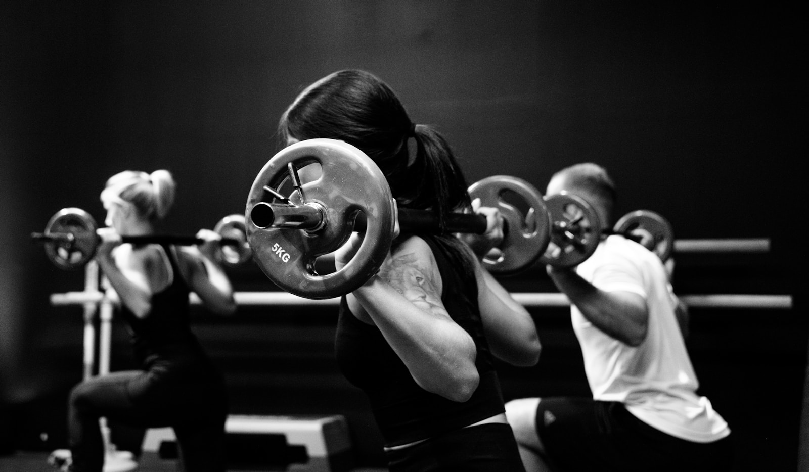 Small-group barbell training in black and white